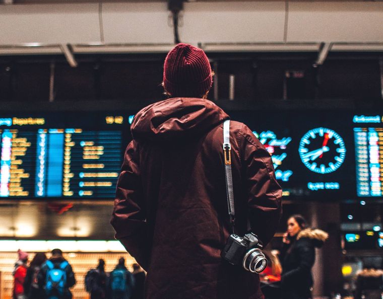 Back view of a man standing in front of departure boards